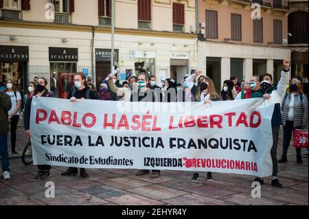 Malaga, Espagne. 20 février 2021. Des manifestants tenant une grande bannière, scandant des slogans réclamant la liberté pendant la manifestation. Pablo Hasel, chanteur de rappeurs, a été condamné pour avoir glorifié le terrorisme et insulté la couronne espagnole et les institutions de l'État par ses chansons et ses tweets. De fortes émeutes ont éclaté dans plusieurs villes après son incarcération au cours des derniers jours, comme une réponse en faveur de la liberté d'expression. Crédit : SOPA Images Limited/Alamy Live News Banque D'Images