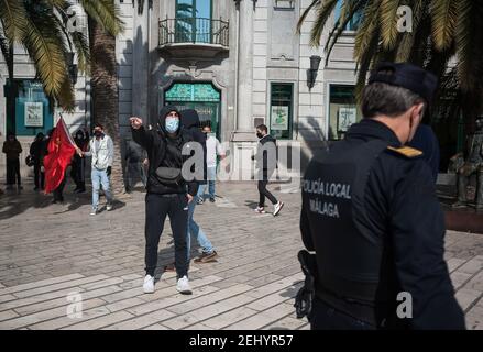 Malaga, Espagne. 20 février 2021. Un manifestant criait à un policier local pendant la manifestation. Pablo Hasel, chanteur de rappeurs, a été condamné pour avoir glorifié le terrorisme et insulté la couronne espagnole et les institutions de l'État par ses chansons et ses tweets. De fortes émeutes ont éclaté dans plusieurs villes après son incarcération au cours des derniers jours, comme une réponse en faveur de la liberté d'expression. Crédit : SOPA Images Limited/Alamy Live News Banque D'Images