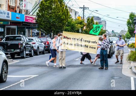 Melbourne, Australie. 20 février 2021. Les militants de la rébellion de l'extinction (XR) se tiennent au milieu de la route tout en tenant une bannière pendant la manifestation.les activistes de la rébellion de l'extinction ont pris dans la rue dans la rue commerçante Bentleigh, Melbourne, en Australie, environ 10 personnes ont assisté à un petit rassemblement, en utilisant un passage pour piétons comme plate-forme pour envoyer un message sur le changement climatique. Chaque feu rouge a été utilisé pour se tenir devant des voitures avec des bannières. Crédit : SOPA Images Limited/Alamy Live News Banque D'Images