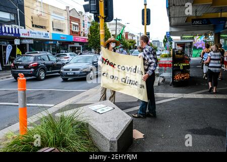 Melbourne, Australie. 20 février 2021. Les activistes de la rébellion de l'extinction (XR) se tiennent à l'écart de la route tout en tenant une bannière pendant la manifestation.les activistes de la rébellion de l'extinction ont pris dans la rue dans la rue commerçante Bentleigh, Melbourne, en Australie, environ 10 personnes ont assisté à un petit rassemblement, en utilisant un passage pour piétons comme plate-forme pour envoyer un message sur le changement climatique. Chaque feu rouge a été utilisé pour se tenir devant des voitures avec des bannières. Crédit : SOPA Images Limited/Alamy Live News Banque D'Images