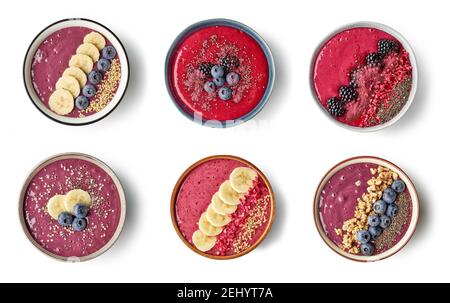 plusieurs bols de smoothie de petit déjeuner sain de banane et de baies isolées sur fond blanc, vue de dessus Banque D'Images