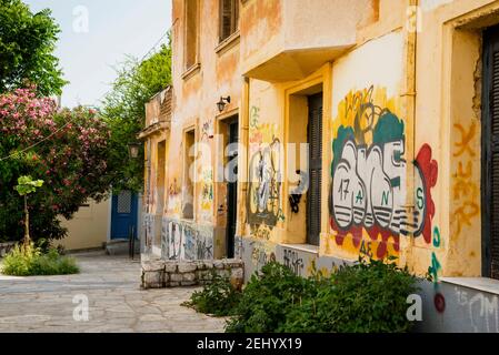 Une cour tranquille en pierre contrastant avec des murs couverts de graffitis à Athènes, en Grèce. Banque D'Images
