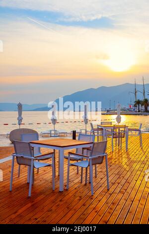 Café en plein air au bord de la mer au coucher du soleil, Tivat, Monténégro Banque D'Images