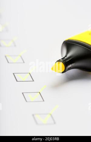 Marqueur jaune avec marqueurs sur la feuille de liste de contrôle. Concept de la tâche terminée de la liste de contrôle. Banque D'Images