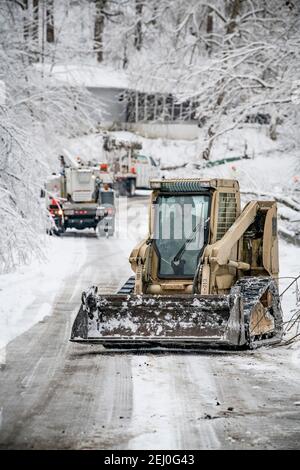 Ceredo, États-Unis. 19 février 2021. Les soldats américains de la Garde nationale de Virginie-Occidentale dépovent les débris d'une tempête d'hiver au large d'une route le 19 février 2021 à Ceredo, dans le comté de Wayne, en Virginie-Occidentale. Plus tôt dans la semaine, un grand système de tempête d'hiver a laissé plus de 90,000 Virginie occidentale sans électricité dans toute la région, faulant les arbres et rendant les routes éloignées impraticables. Credit: Planetpix/Alamy Live News Banque D'Images