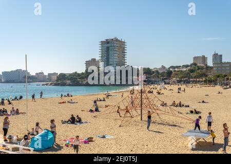 Palmanova, Espagne; février 20 2021: vue générale de la marina et de la plage de la station majorquine de Palmanova par une journée ensoleillée, avec des familles qui profitent de la vue Banque D'Images