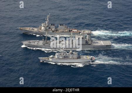 Le destroyer à missiles guidés USS Curtis Wilbur, de la Marine américaine Arleigh Burke, mène un réapprovisionnement en mer avec le navire de ravitaillement de la Force maritime autonome de défense japonaise de la classe Towada JS Hamana, au centre, et la frégate légère française de classe Floreal FNS Prairial lors d'opérations conjointes le 19 février 2021 dans l'océan Pacifique. Banque D'Images