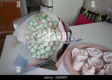 Bouquet de Zephyr. Les tulipes de guimauve sont récoltées dans un bouquet et enveloppées dans du papier. Il y a des roses zephyr sur la table. Banque D'Images