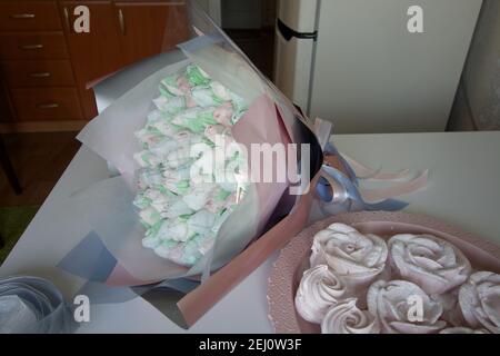 Bouquet de Zephyr. Les tulipes de guimauve sont récoltées dans un bouquet et enveloppées dans du papier. Il y a des roses zephyr sur la table. Banque D'Images
