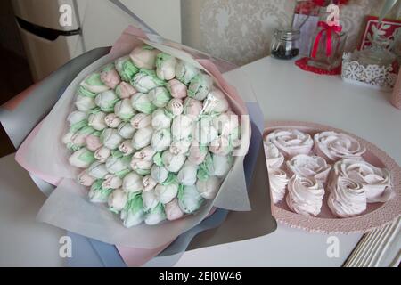 Bouquet de Zephyr. Les tulipes de guimauve sont récoltées dans un bouquet et enveloppées dans du papier. Il y a des roses zephyr sur la table. Banque D'Images