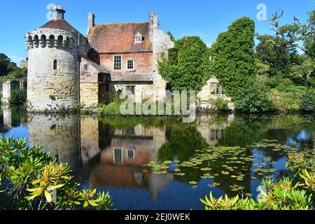 Façade de château médiéval britannique datant de plusieurs siècles au milieu d'une végétation luxuriante avec Son reflet dans l'eau il comprend des bâtiments résidentiels de tour de domaines bureau Banque D'Images