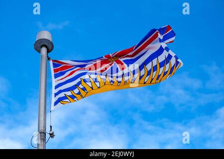 Vue à angle bas du drapeau de la province canadienne de la Colombie-Britannique (C.-B.) sur un mât. Banque D'Images