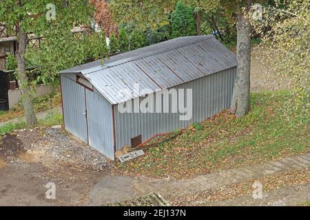 Structure de garage en métal caché dans les bois Banque D'Images