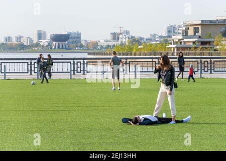 Kazan, Russie-26 septembre 2020 : les habitants de la ville se détendent et jouent avec les enfants sur la pelouse d'un terrain de football artificiel dans le parc de la ville Banque D'Images