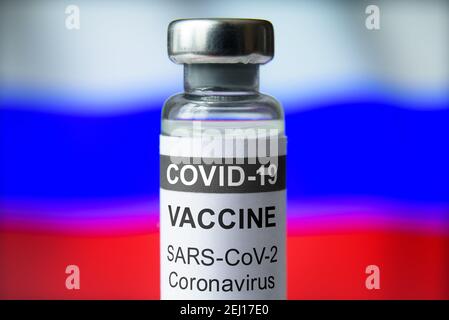 Vaccin COVID-19 sur fond de drapeau russe, flacon avec le vaccin Spoutnik V pour le coronavirus en gros plan. Concept de traitement, essai clinique, distribution Banque D'Images