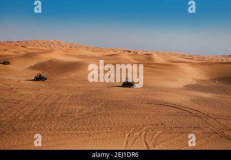 Magnifique paysage sauvage du désert arabe avec deux voitures en buggy, quads au safari des dunes de sable de Dubaï Banque D'Images