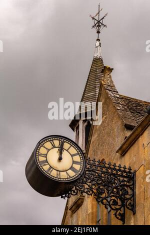Une vieille horloge dans un mur de pierre contre un ciel nuageux ciel Banque D'Images