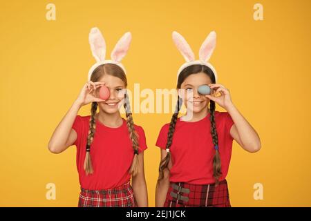 Mignons petites filles portant des oreilles de lapin. Composition de Pâques. Chasse aux œufs. Vacances de printemps traditionnelles. Joyeuses pâques. Printemps à venir. Enfants de lapins de Pâques. Les enfants jouent dans les oreilles de lapin. Banque D'Images