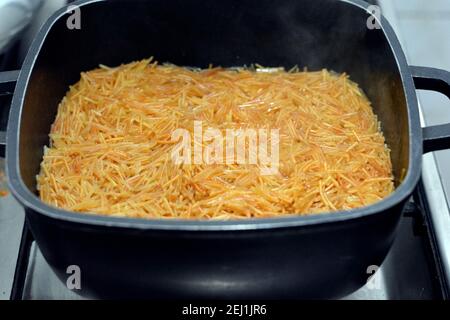 Bruni dans du beurre doux vermicelles égyptiennes cuites avec de l'eau et du sucre dans une casserole, dessert égyptien traditionnel en fin de déjeuner et tôt le dîner Banque D'Images