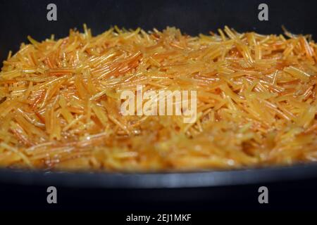 Bruni dans du beurre doux vermicelles égyptiennes cuites avec de l'eau et du sucre dans une casserole, dessert égyptien traditionnel en fin de déjeuner et tôt le dîner Banque D'Images