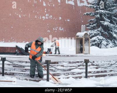 Moscou. Russie. 12 février 2021. Les employés des services publics retirent la neige à l'aide d'un souffleur à neige et de pelles lors d'une chute de neige près du mur du Kremlin, à la tombe de Banque D'Images