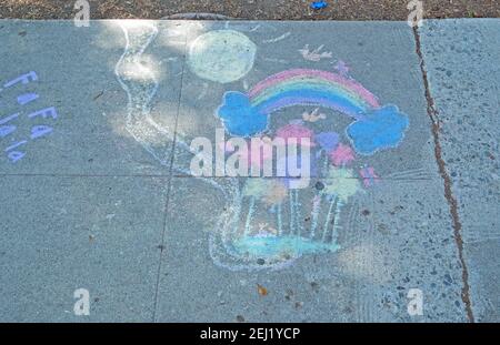 Trottoir, dessin à la craie avec arc-en-ciel et soleil. Banque D'Images