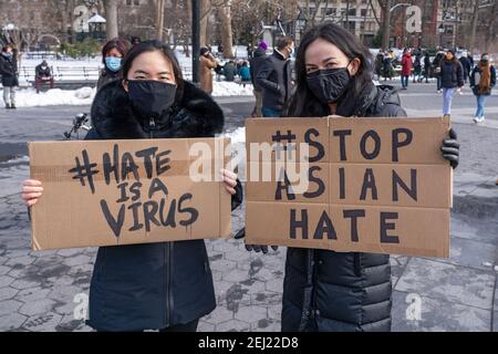 New York, États-Unis. 20 février 2021. NEW YORK, NY - 20 FÉVRIER : des manifestants brandistent des signes indiquant « la haine est un virus » et « la haine asiatique » à la fin, la violence envers les Asiatiques se rallie à Washington Square Park le 20 février 2021 à New York. Depuis le début de la pandémie du coronavirus, la violence envers les Américains asiatiques a augmenté à un taux beaucoup plus élevé que les années précédentes. Le département de police de la ville de New York (NYPD) a signalé une augmentation de 1,900 % des crimes haineux anti-asiatiques en 2020. Crédit : Ron Adar/Alay Live News Banque D'Images