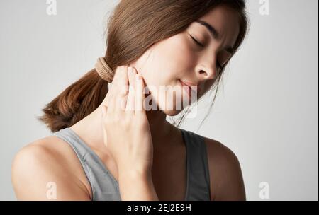 femme en t-shirt gris problèmes de santé tient la main près du visage douleur inconfort Banque D'Images