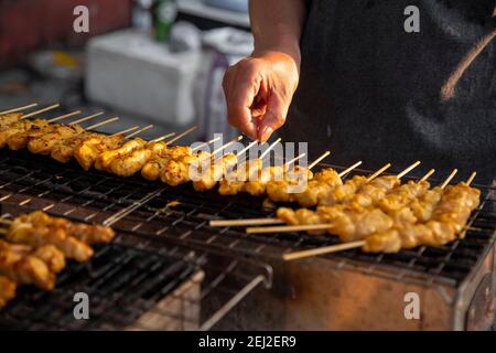 Les brochettes de viande cuisent sur des plats chauds au marché alimentaire de Satay Street. Délicieux satay Banque D'Images