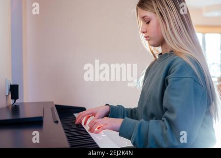 Petite fille apprenant à jouer du piano électrique Banque D'Images