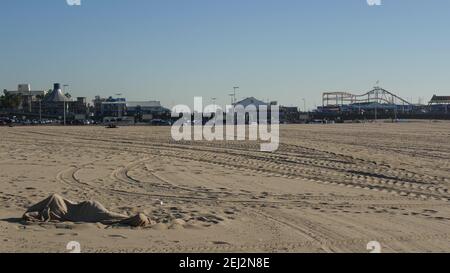 SANTA MONICA, LOS ANGELES CA USA - 19 DEC 2019: Seul l'homme anonyme ressemble à des chômeurs et sans-abri dormant sur le sable de la plage. Sans-abri et mendicité Banque D'Images