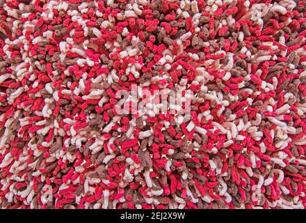 Arrière-plan et texture de tapis rouge foncé et rose avec de longs cheveux. Éléments de conception Banque D'Images