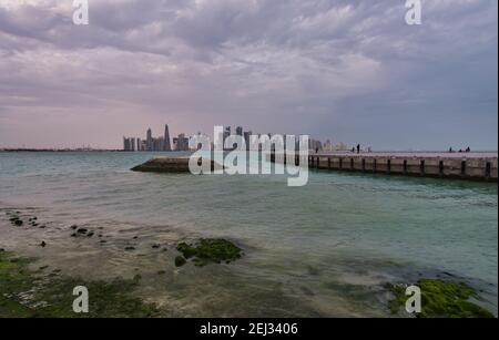 Vue panoramique de Doha depuis la promenade de la corniche l'après-midi Montrant des huws avec le drapeau du Qatar dans le golfe arabe à premier plan Banque D'Images