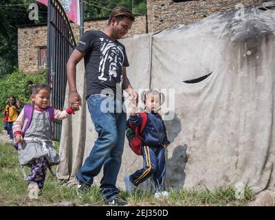 Pokhara, Népal. 09-15-2017. Le père d'un village dans les montagnes du Népal emmène ses filles à l'école. Banque D'Images