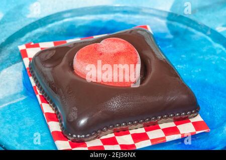 Glace végétalienne pour la Saint-Valentin, chocolat et fraise, forme de coeur, sur une assiette en verre Banque D'Images