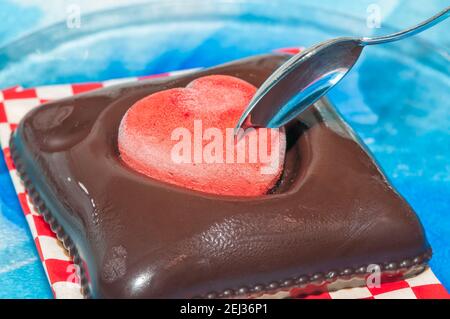 Glace végétalienne pour la Saint-Valentin, chocolat et fraise, forme de coeur, sur une assiette en verre Banque D'Images