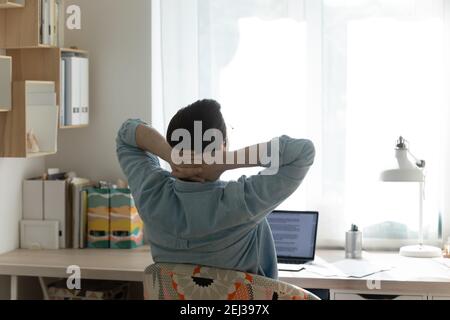 Vue arrière de l'homme détendez-vous dans une chaise au bureau à la maison Banque D'Images