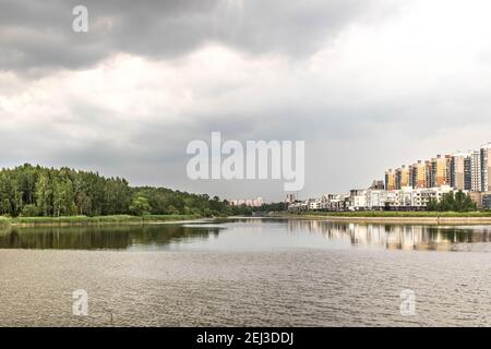 La côte du golfe de Finlande avec des bâtiments modernes. Île et parc à l'horizon. Banque D'Images