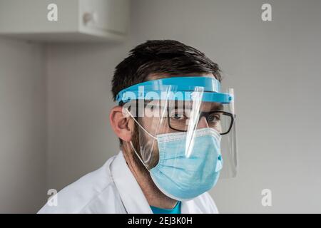 Portrait d'un médecin de sexe masculin portant un masque et un visage de protection protection Banque D'Images