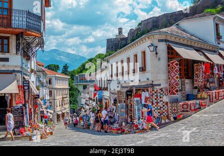 Ville de Gjirokaster, Albanie – 2 août 2020 : paysage urbain d'été – rue de la vieille ville avec boutiques de souvenirs et touristes. Ancienne architecture historique et Banque D'Images