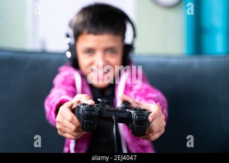 Gros plan sur la manette de jeu, les enfants s'amusent au jeu vidéo à l'aide d'une manette de jeu à la maison tout en étant assis sur un canapé. Banque D'Images