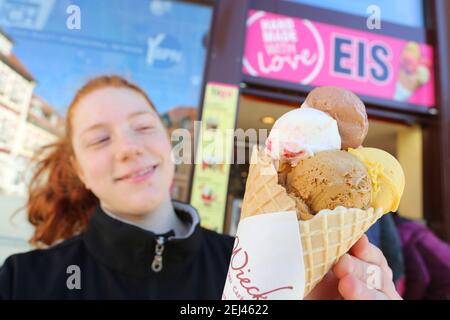 21 février 2021, Saxe-Anhalt, Wernigerode: Monique est heureuse de sa grande glace sur le marché. De nombreuses personnes ont profité des températures printanières pendant le week-end pour un voyage dans les montagnes Harz. Photo: Matthias Bein/dpa-Zentralbild/dpa Banque D'Images