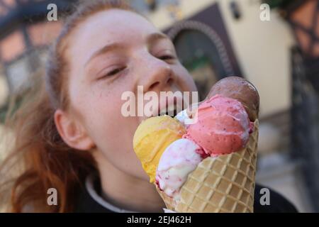 21 février 2021, Saxe-Anhalt, Wernigerode: Monique est heureuse de sa grande glace sur le marché. De nombreuses personnes ont profité des températures printanières pendant le week-end pour un voyage dans les montagnes Harz. Photo: Matthias Bein/dpa-Zentralbild/dpa Banque D'Images