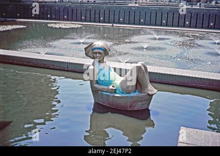 Une sculpture de 1989, faisant partie de la série « flottante » d’André Wallace, installée au complexe Barbican, Londres, Angleterre, Royaume-Uni 1993. Cette figure féminine dans un maillot de bain fait partie de son travail du vent du changement. Cette œuvre faisait partie de l’« Art in the City » de 1993 et visait à faire de la sculpture une place parmi les espaces verts et l’architecture distinctive de la City de Londres. André Wallace (1947) est un sculpteur et artiste travaillant dans le bronze, la pierre, la résine translucide et divers métaux et produit également des œuvres sur papier. Il travaille souvent à grande échelle. Banque D'Images