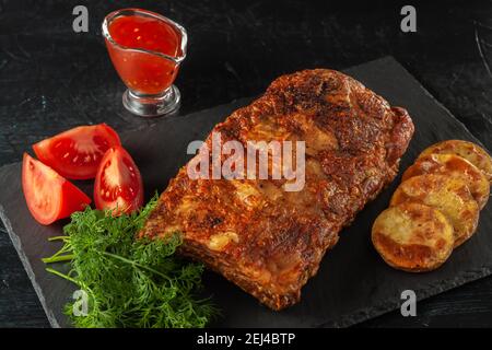 Côtes épicées grillées servies avec de la sauce au Chili chaud et fraîches Tomates Banque D'Images