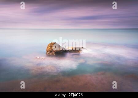 Rochers, mer douce et nuages dans le ciel, beau paysage en photographie en exposition longue. Castiglioncello, Toscane, Italie. Banque D'Images