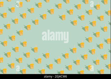 Motif abstrait fait de sorbet jaune pastel crème glacée pop sur fond vert menthe pastel. Un minimum de temps de pose. Banque D'Images