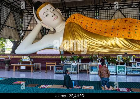 Pèlerins priant devant un bouddha couché, pagode su taung pyi, Myitkyina, état de Kachin, Myanmar Banque D'Images