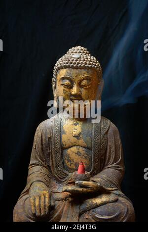 Bouddha avec cône d'encens brûlant Banque D'Images