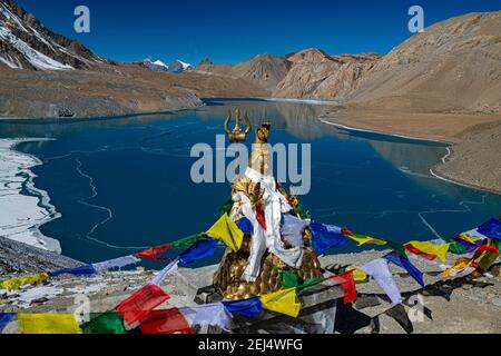 Lac Tilicho recouvert de glace devant le paysage de montagne avec des drapeaux de prière bouddhistes et la statue hindoue de Shiva, souvent appelé le lac le plus haut dans le Banque D'Images